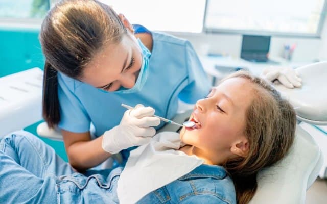 Dental professional speaking with a patient in a treatment room