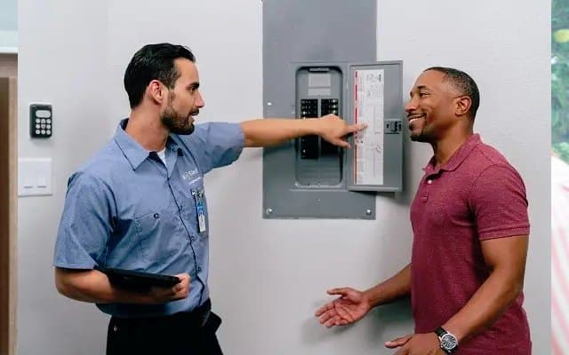 Electrician speaking with a homeowner about electrical work