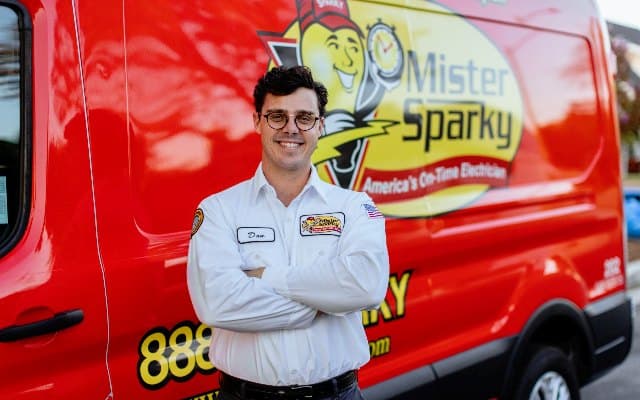 Electrical service van and technician performing installation work