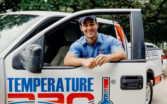 HVAC service vehicle and technician performing installation or repair work