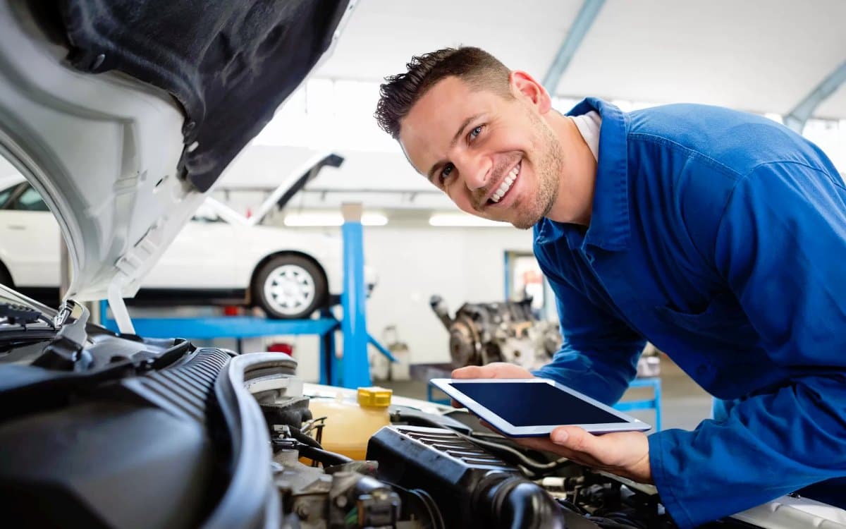 Auto mechanic working on a vehicle in a repair bay